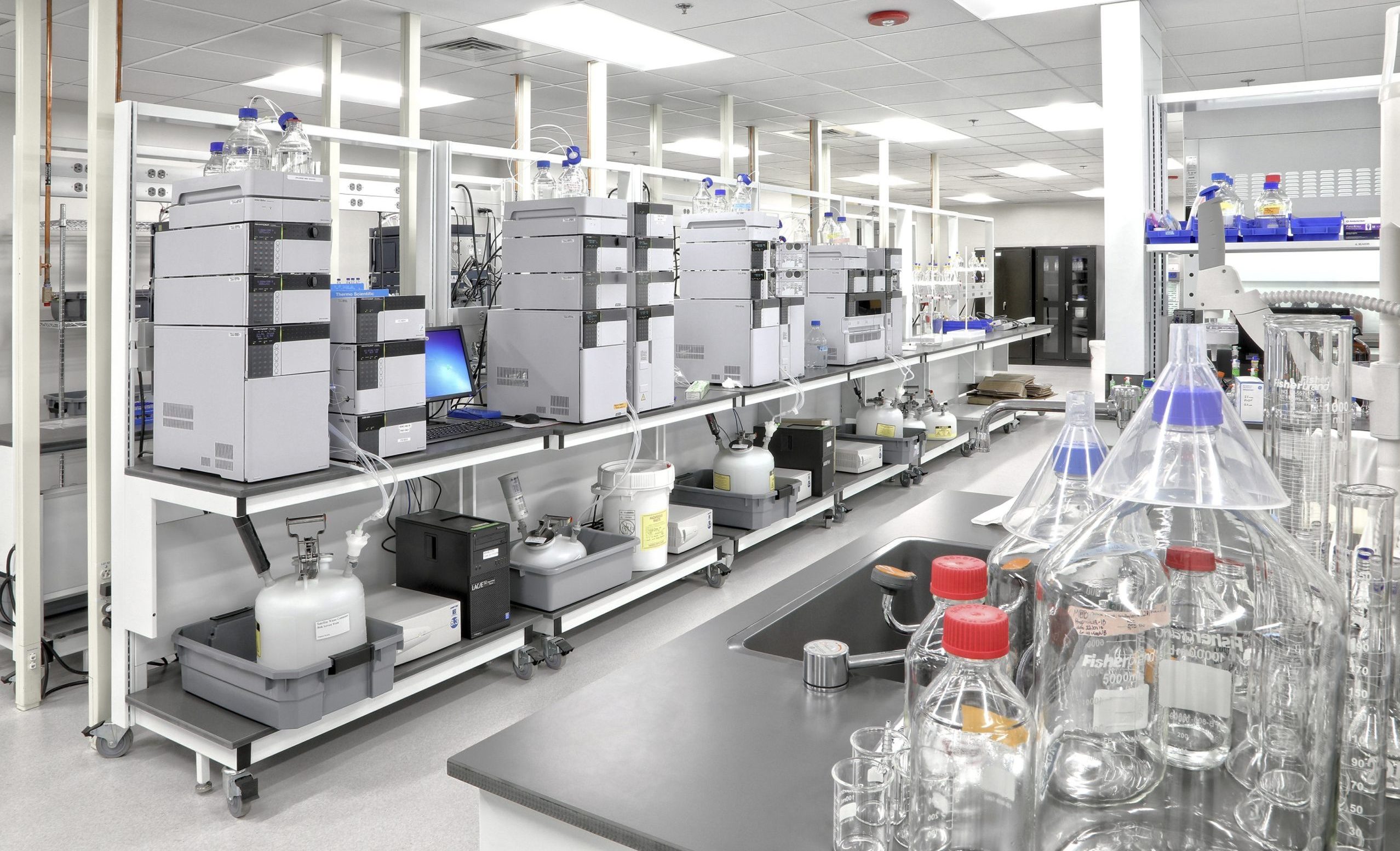 Full height Sigma Carts with lower shelving - work tops and lower shelves filled with lab equipment and glassware, in a lab